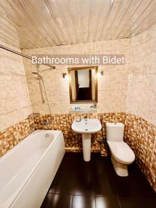 a bathroom with a tub and a sink and a toilet at Hotel British House in Tbilisi City