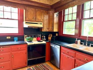 a kitchen with red cabinets and a stove top oven at Camden at Monticello in Salisbury +33 photos