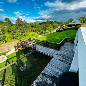 a deck with a picnic table and a swing at Hobbitul lui Maș in Valea lui Maş