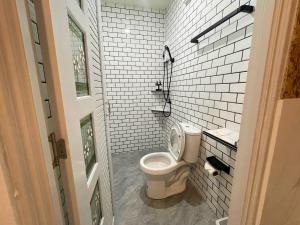 a bathroom with a toilet and a white tile wall at Manta Resort in Ban Khao Tok +60 photos