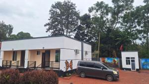 a van parked in front of a white house at Escape Villa - Kilimanjaro in Moshi