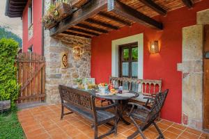 a table and chairs on a patio with a red wall at Casa Del Tesoro in Triongo