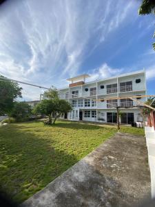a large white building with a grass yard at Dapdap Shorelines Beachfront Villa in Camotes Islands