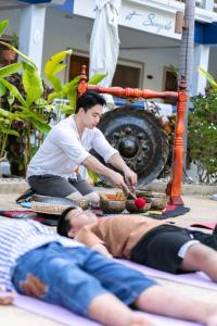 a group of people laying on the floor in a yoga class at The Beach Wellness Residence in Ban Pru Yai +18 photos