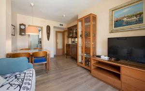 a living room with a television and a dining room at Miquel 2 – Apartamento con Parking, Wifi y A/C in Tossa de Mar