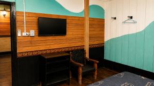 ein Zimmer mit Kamin und einem Fernseher an der Wand in der Unterkunft โรงแรมคุ้มเดช - KoomDech Hotel in Sattahip