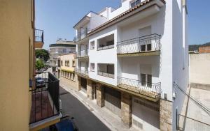 an apartment building with balconies on a city street at Miquel 2 – Apartamento con Parking, Wifi y A/C in Tossa de Mar