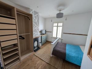 a bedroom with a bed and a tv and a window at Quaint Cottage in Charming Evesham in Evesham