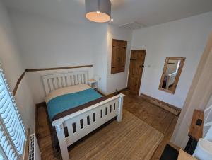 a small bedroom with a bed and a mirror at Quaint Cottage in Charming Evesham in Evesham