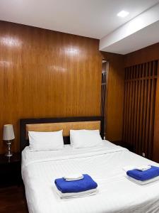 a bedroom with a large bed with blue towels on it at Q Kata Residence in Kata Beach