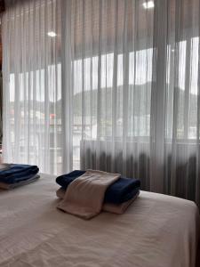 a bed with white curtains in front of a window at Q Kata Residence in Kata Beach
