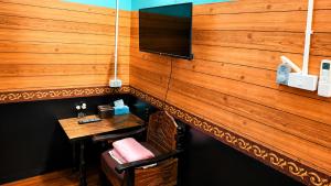 eine Bar mit einem Tisch und einem Fernseher an der Wand in der Unterkunft โรงแรมคุ้มเดช - KoomDech Hotel in Sattahip