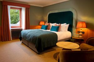 a bedroom with a large bed and a window at The Mill House in Stewarton