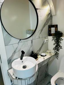 a bathroom with a white sink and a mirror at Hobbitul lui Maș in Valea lui Maş +40 photos
