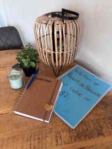 a desk with a notebook and a pen and a note at Cube 97 I 4 persoons chalet met hottub in Zennewijnen