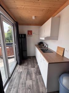 a kitchen with white cabinets and a large window at Cube 97 I 4 persoons chalet met hottub in Zennewijnen