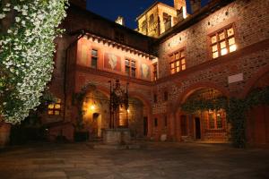 a large brick building with a courtyard at night at Castello Di Pavone in Pavone Canavese