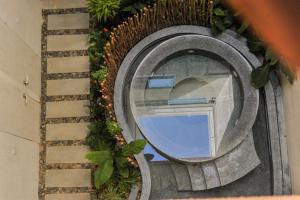 a mirror on the side of a building with plants at Camfusion Hoi An in Hoi An