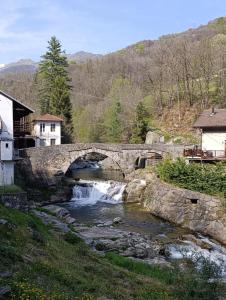 a stone bridge over a river with a waterfall at Dal Brascin in Corio