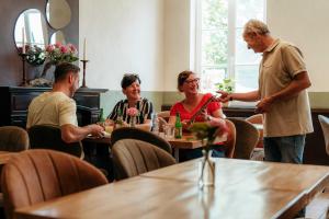 un gruppo di persone sedute ai tavoli di un ristorante di De Pastorie a Borgloon