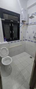 a bathroom with a toilet and a window at Aangan Homestay in Pātan