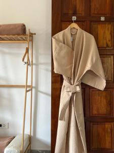 a robe hanging in front of a door at The Beach Wellness Residence in Ban Pru Yai