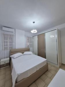 a bedroom with a large bed with white sheets at Lushnja Central Elegance in Lushnjë