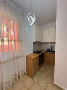 a kitchen with white cabinets and a window at Lushnja Central Elegance in Lushnjë +5 photos