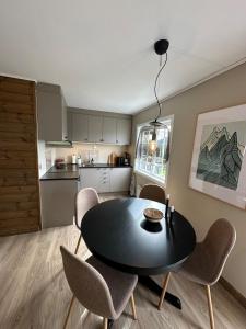 a dining room with a black table and chairs at Oppdal Alpintun in Oppdal