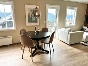 a dining room with a table and chairs and a couch at Oppdal Alpintun in Oppdal