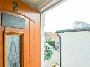 a door to a building with a sign on it at Cygnet Cottage - Uk43546 in Belford