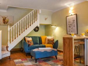 a living room with a couch and a staircase at Granary Cottage in Kirkby Malham +9 photos