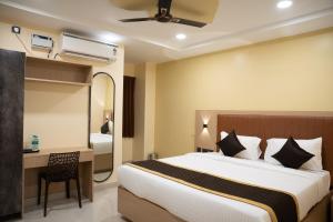 a hotel room with a bed and a desk and a bedroom at RMA Joliday Inn in Pondicherry