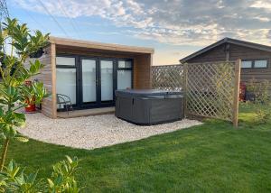 a backyard retreat with a hot tub in the grass at Fine Country Stays in Bubwith