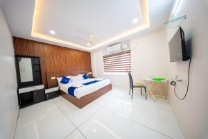 a bedroom with a bed and a tv and a table at BREEZA GRANd in Kazhakuttam +48 photos