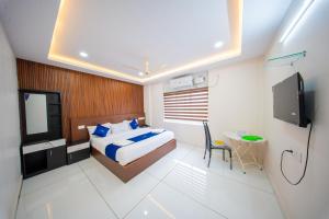 a bedroom with a bed and a television in it at BREEZA GRANd in Kazhakuttam