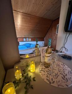 a table with two bottles of whiskey and candles at Meandri Ćehotine in Pljevlja +12 photos