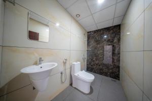 a bathroom with a sink and a toilet and a mirror at BREEZA GRANd in Kazhakuttam