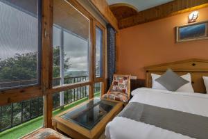 a bedroom with a bed and a large window at Splendid Retreat Hotels Kufri in Kūfrī +11 photos