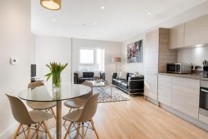 a kitchen and living room with a glass table and chairs at Roomspace Serviced Apartments - Vertex House in Croydon