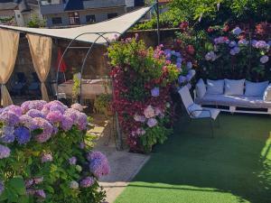 a garden with purple and purple flowers and chairs at Casa do Centro - Alojamento Local in Vieira do Minho