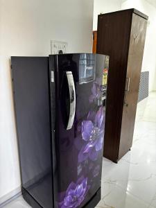 a black refrigerator with purple flowers painted on it at Villa Stay in Pondicherry