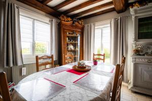 a dining room with a table and two windows at Chambres d'hôtes à Bavent in Bavent