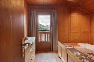 a bedroom with a bed and a large window at Schartenblick in Sarntal