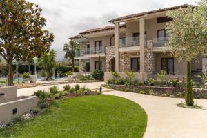 a villa with a lawn in front of it at Nikoleta Hotel and Villas in Limenas