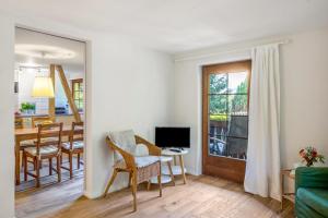 a living room with a table and chairs and a television at Fuchs und Has' Feldberg in Feldberg