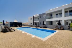a swimming pool in front of a building at Oasis Luxury Escape in Xylophaghou