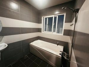 a bathroom with a tub and a sink at Phố Homestay TĐT in Ấp Tân An (1)