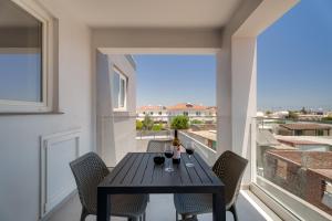 a dining table on a balcony with a view at Oasis Luxury Escape in Xylophaghou