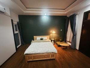 a bedroom with a bed and a green wall at Phố Homestay TĐT in Ấp Tân An (1) +5 photos